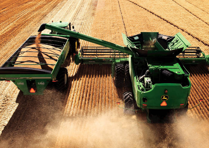 Harvest machinery collecting grain in a crop field